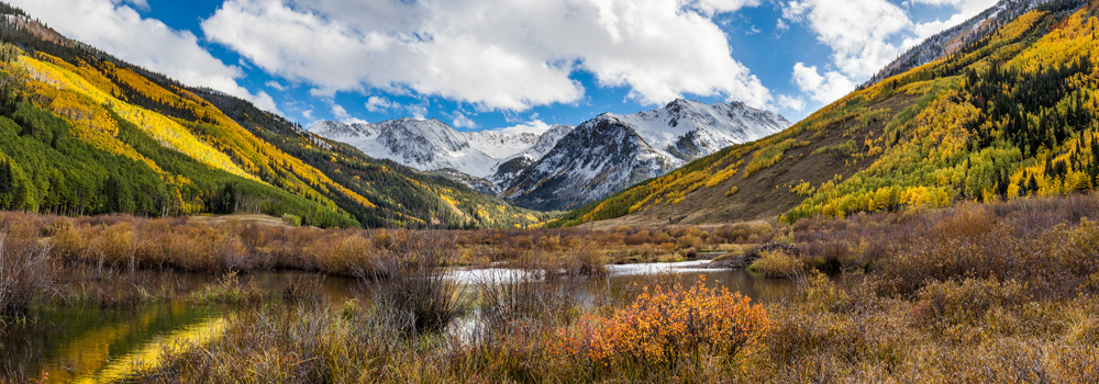 Colorado mountains with autumn colored leaves and snow on the peaks