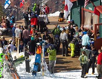 Skiers and snowboarders standing outside a lodge