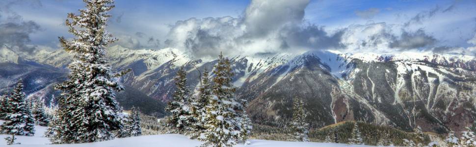 A snowscape with snow covered mountains in the background