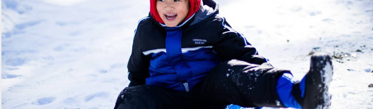 A child sledding down a snowy hill in Aspen